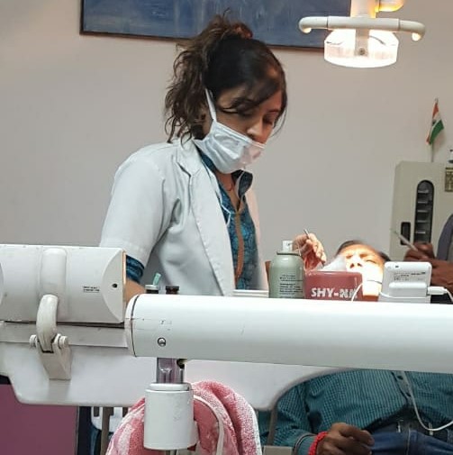 Dr. Surbhi, Expert dentist doing treatment of her patient with care